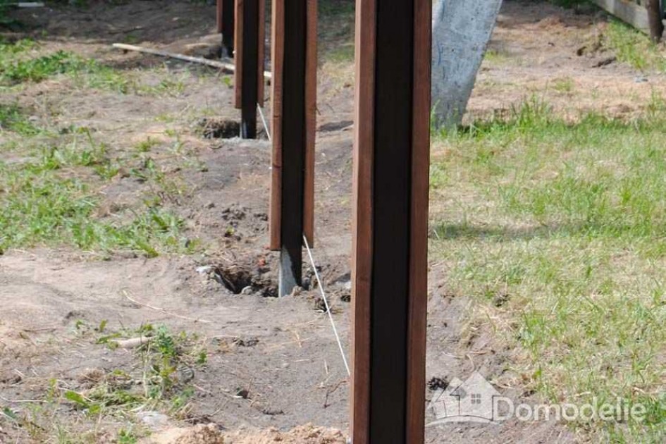 Столб под. Забутовка столбов для забора щебнем. Бутование столбов для забора из дерева. Деревянные столбы под забор. Опоры для деревянного забора.